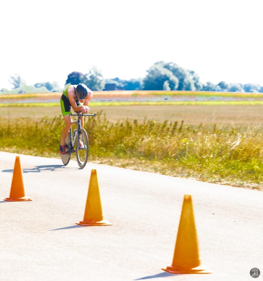 Een persoon fietst op een weg die omgeven is door verkeerskegels