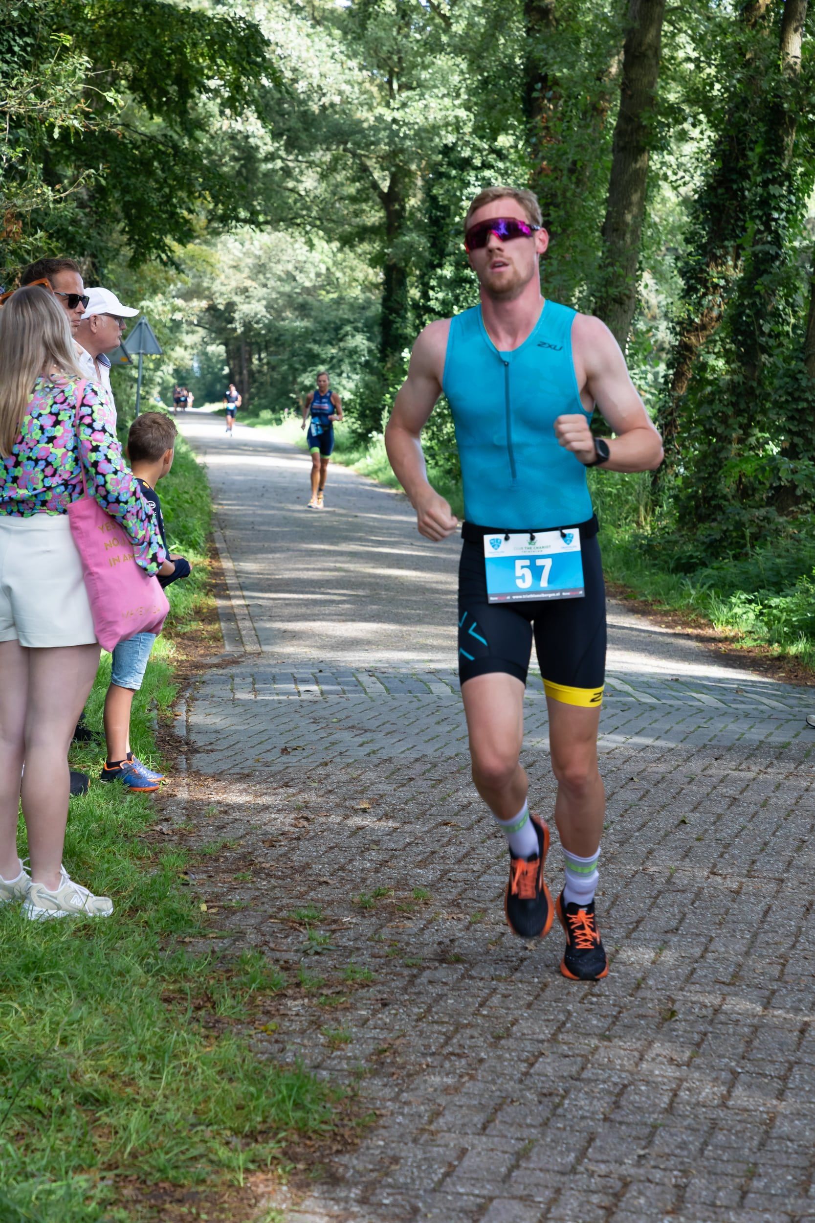 Een man rent over een stenen weg in het bos.