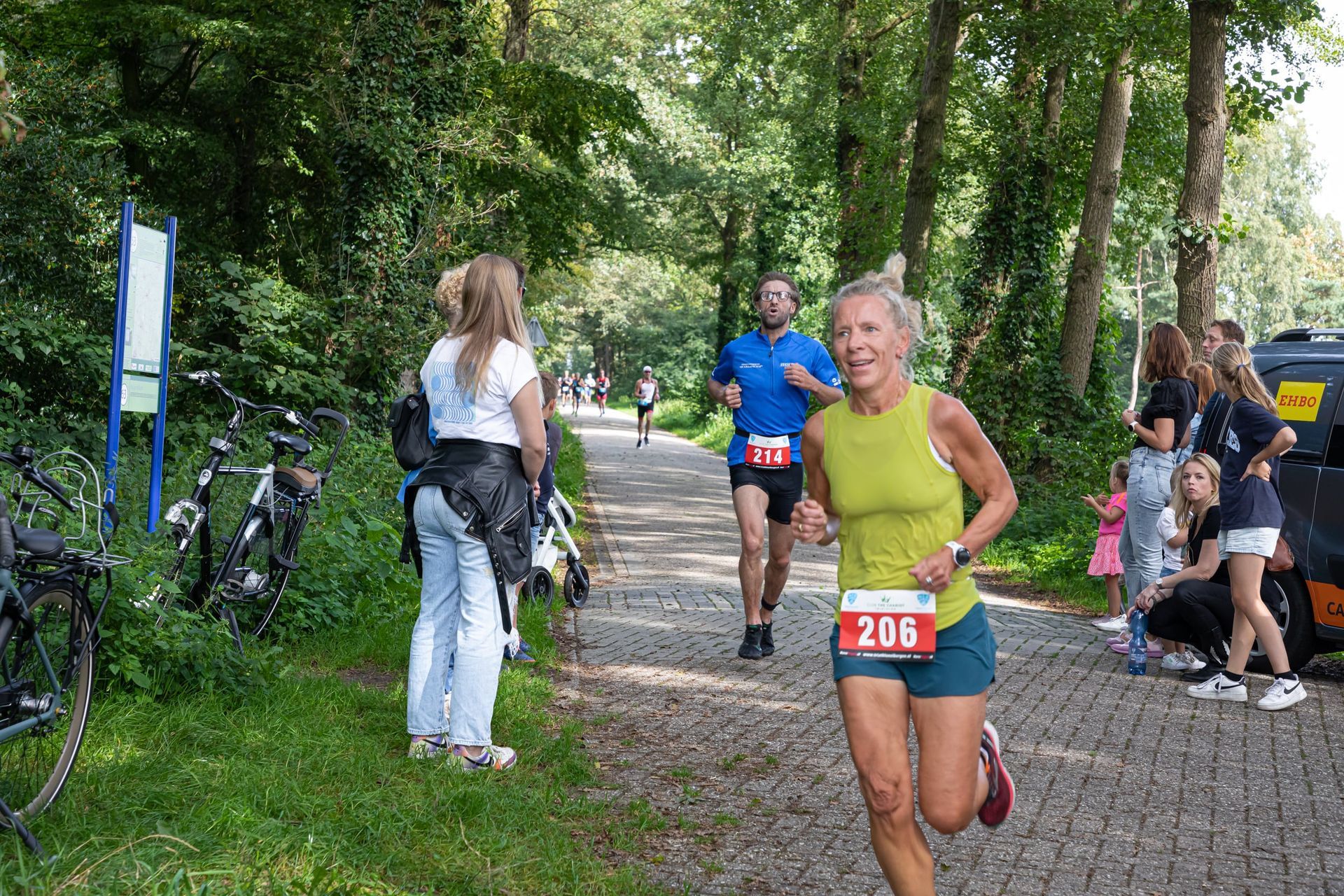Een groep mensen rent een race op een geplaveide weg.