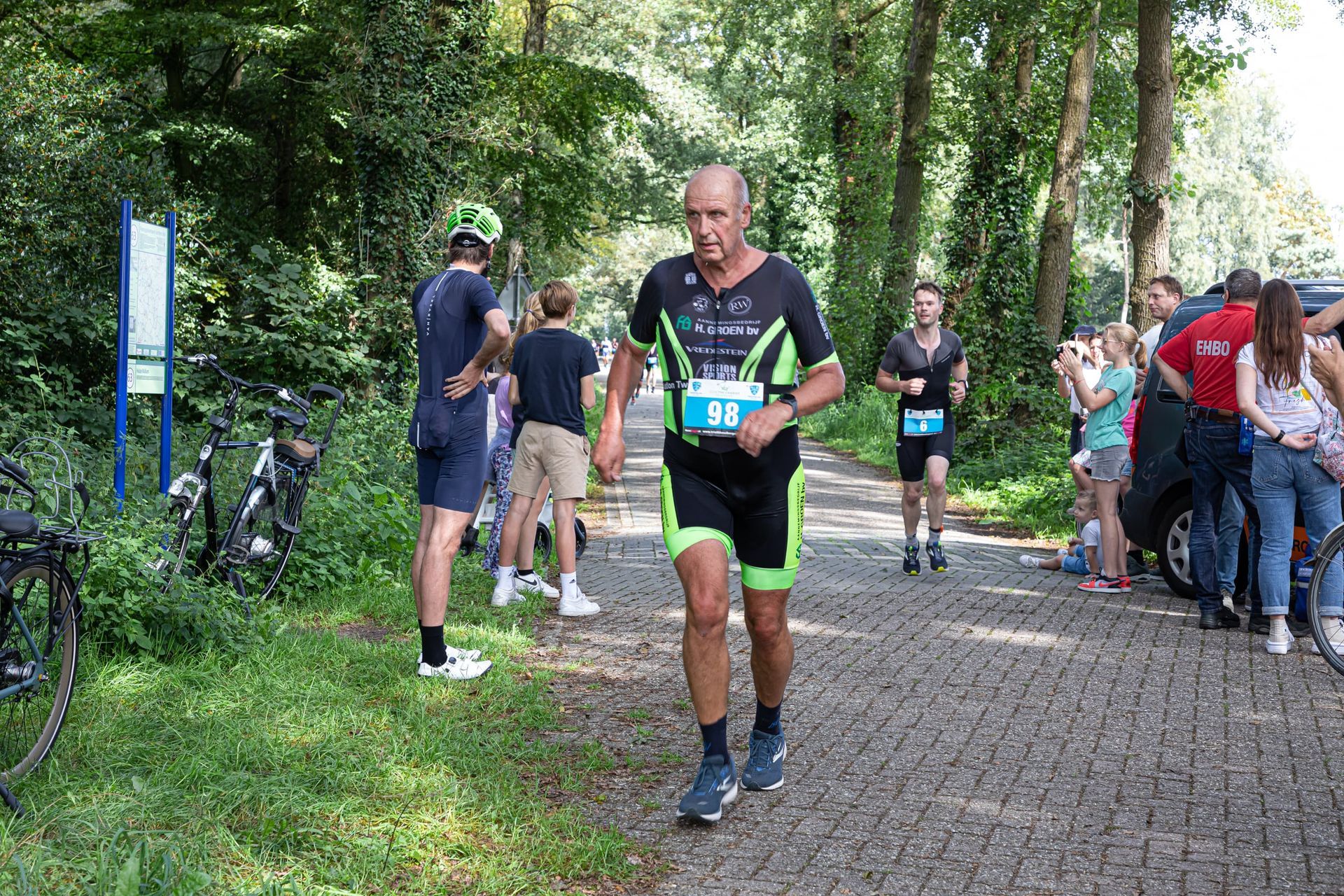 Een man rent een marathon op een geplaveide weg.
