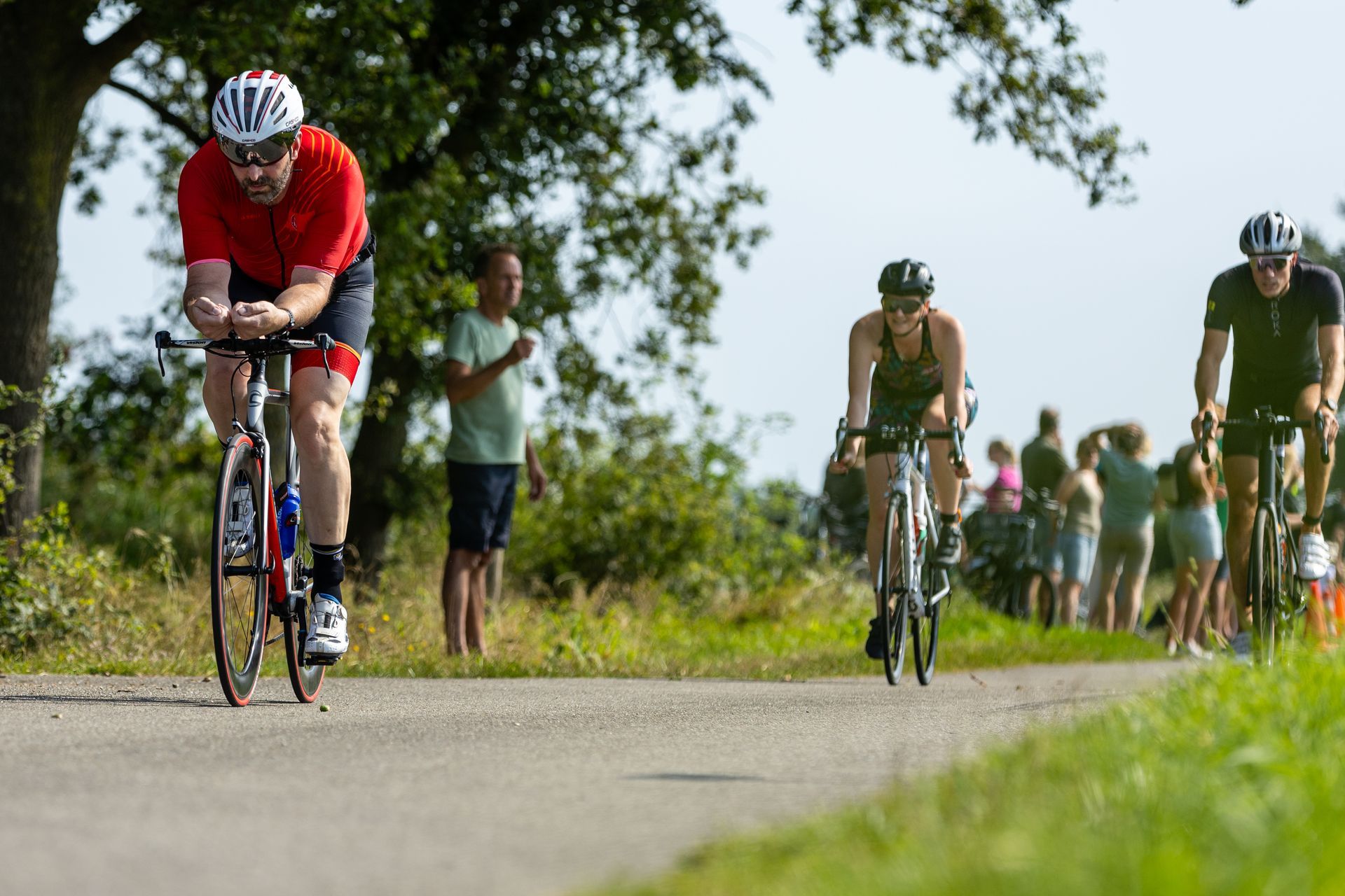 Een groep mensen fietst over een weg.