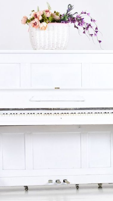 A White Piano With A Vase Of Flowers On Top Of It — Doug Simpson Piano Tuning In Manunda, QLD