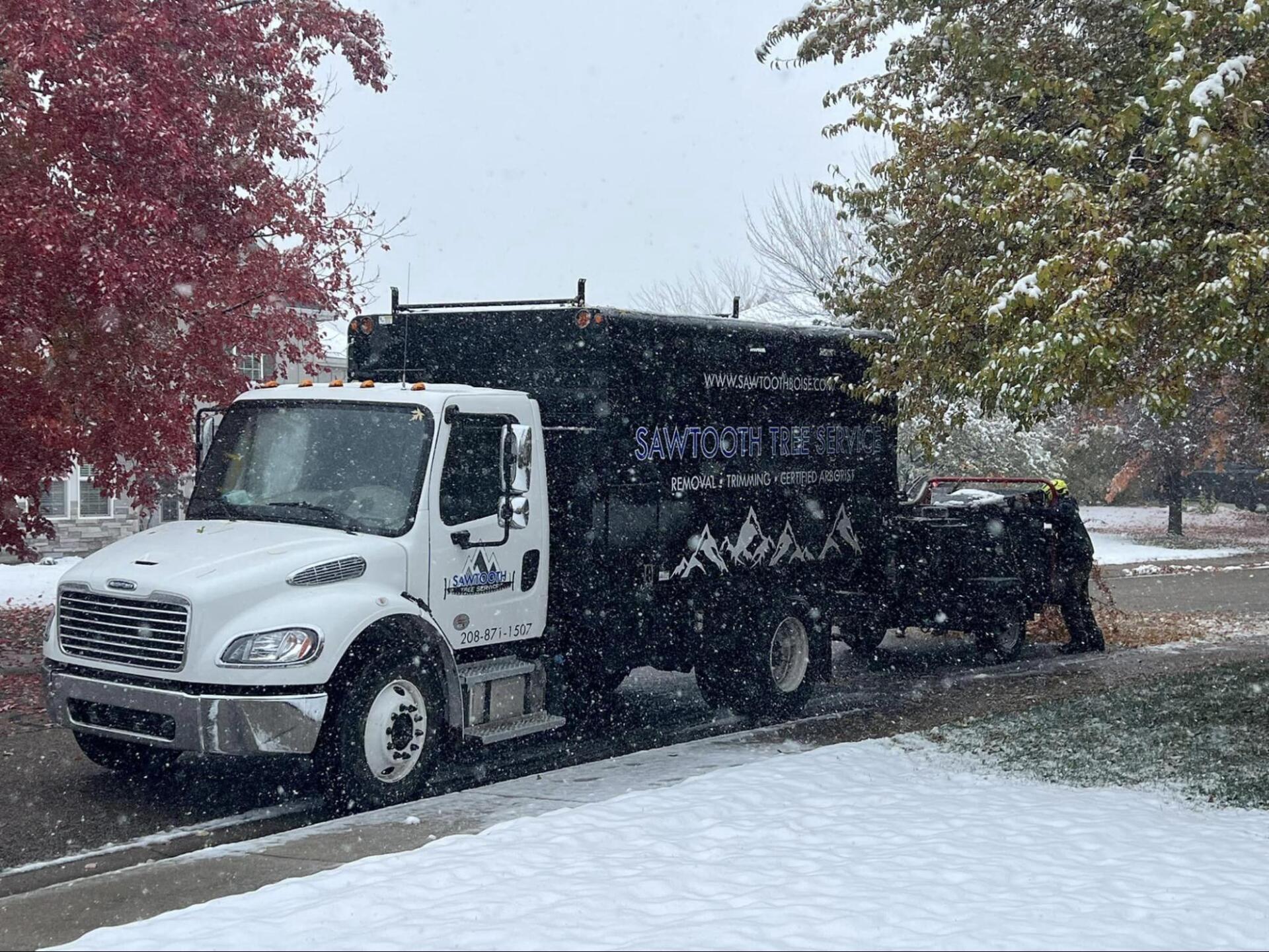 A white truck is parked on the side of the road in the snow.
