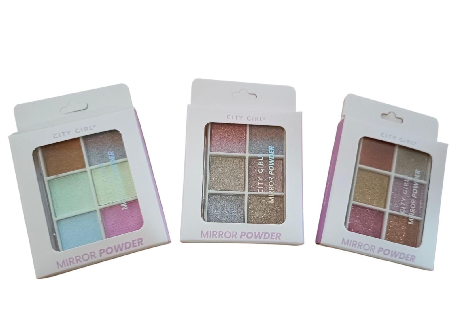 Tres paletas de maquillaje abiertas con sombras de ojos en tonos pastel y con purpurina sobre un fondo blanco.