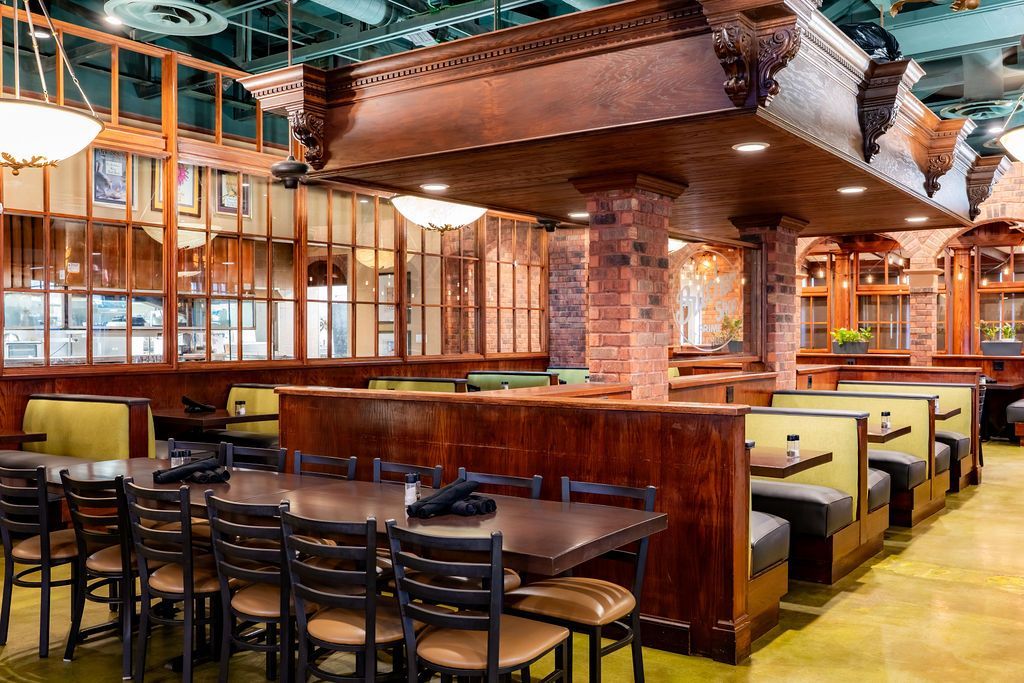 Cozy empty restaurant interior with wood booths, brick walls, and warm lighting