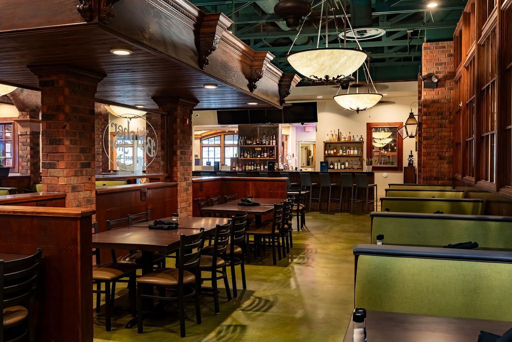 Empty restaurant interior with wooden booths, brick walls, and warm pendant lights