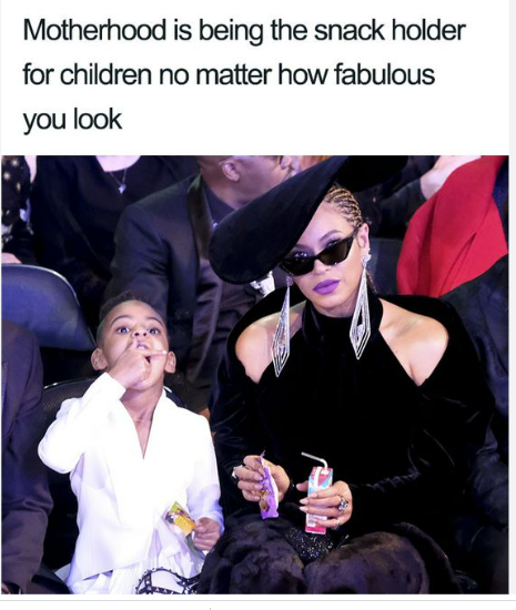 Woman in formal wear hands snacks to child in a public setting.