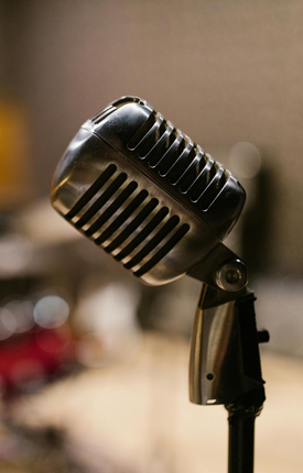 Vintage silver microphone on a stand against a blurred background