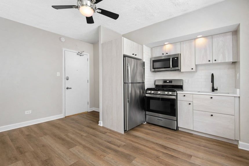 part of living room and kitchen with white cabinets and stainless steel appliances