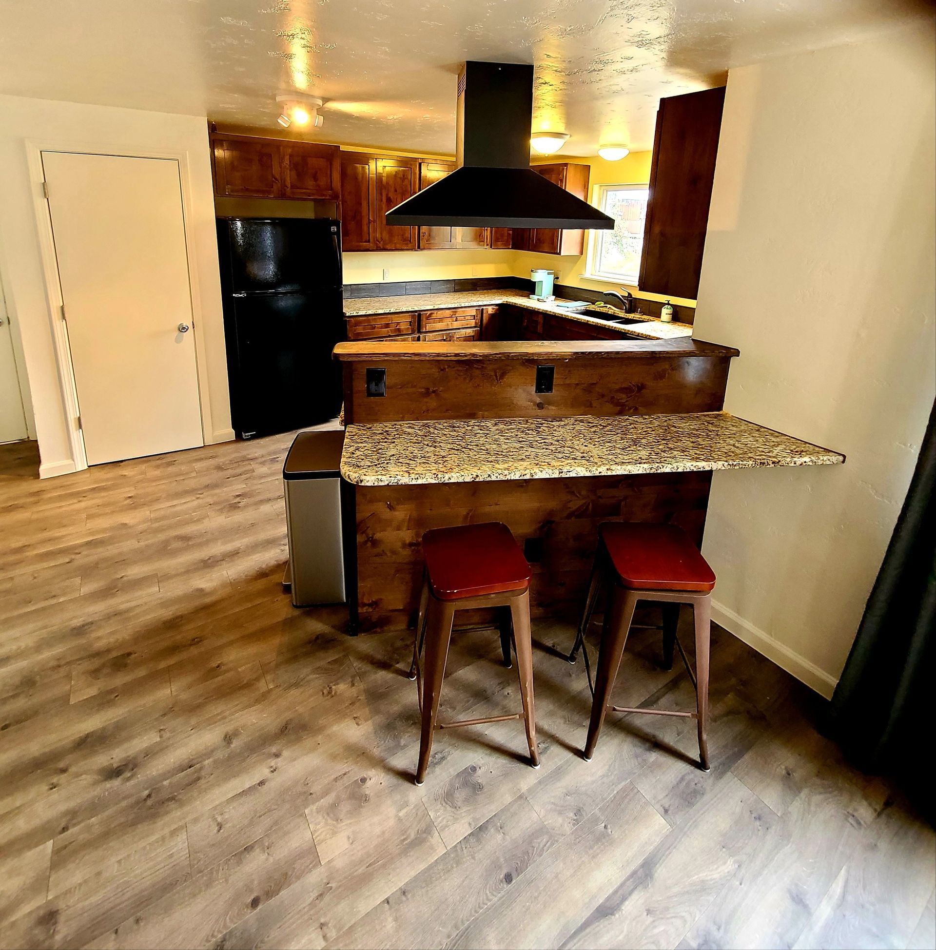 A kitchen with a granite counter top and stools