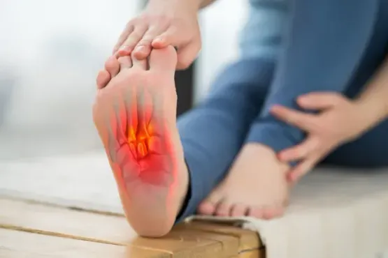 A doctor wearing a mask is examining a patient 's foot.
