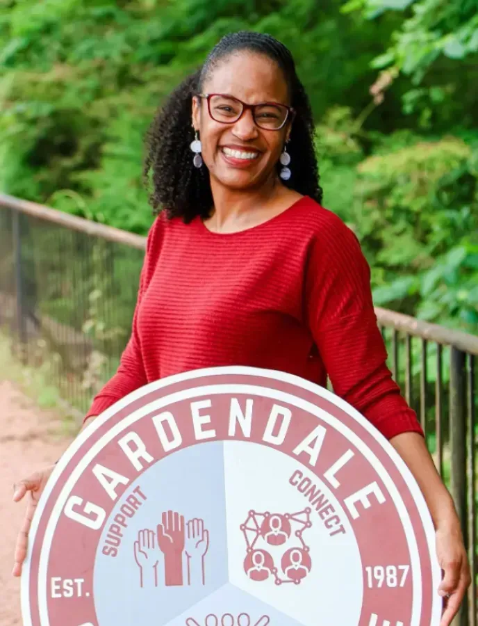 Woman in red shirt smiling, holding a 