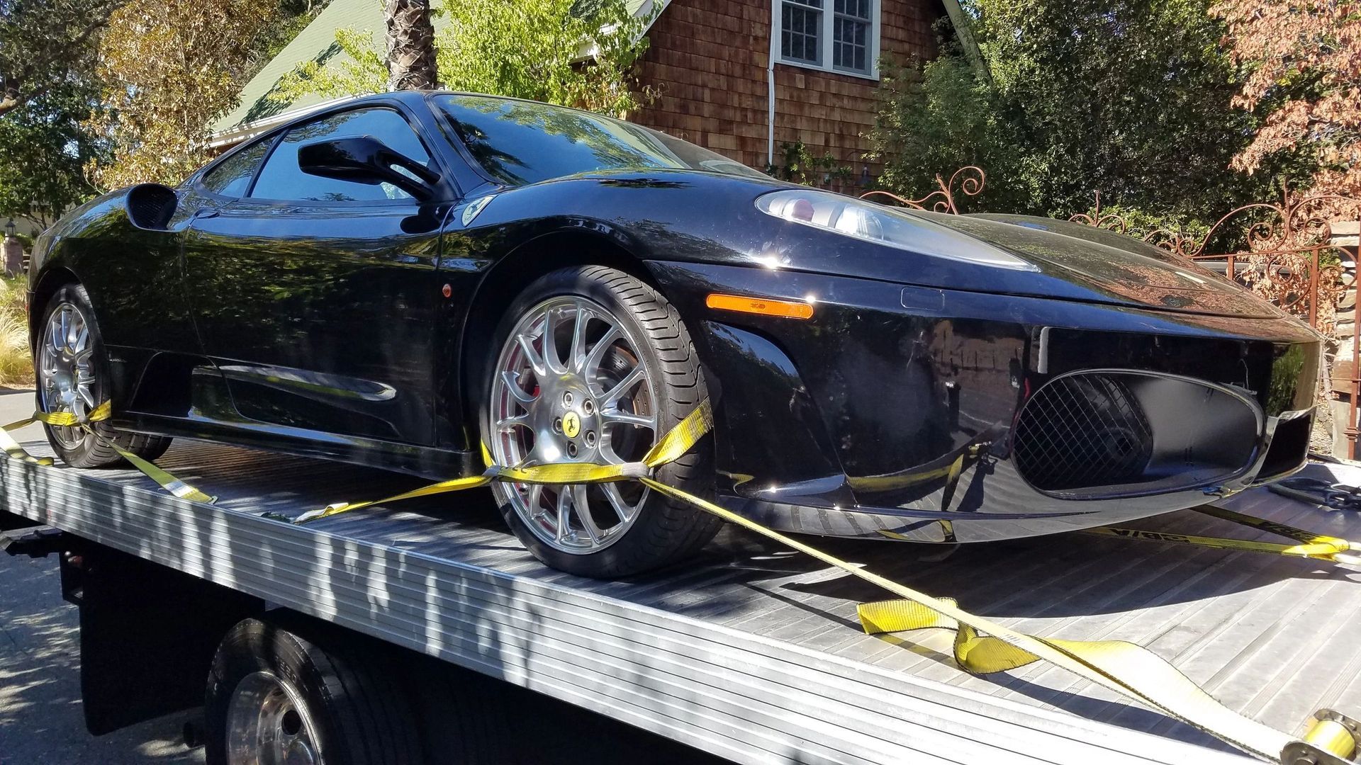 A man is towing a car on a tow truck.