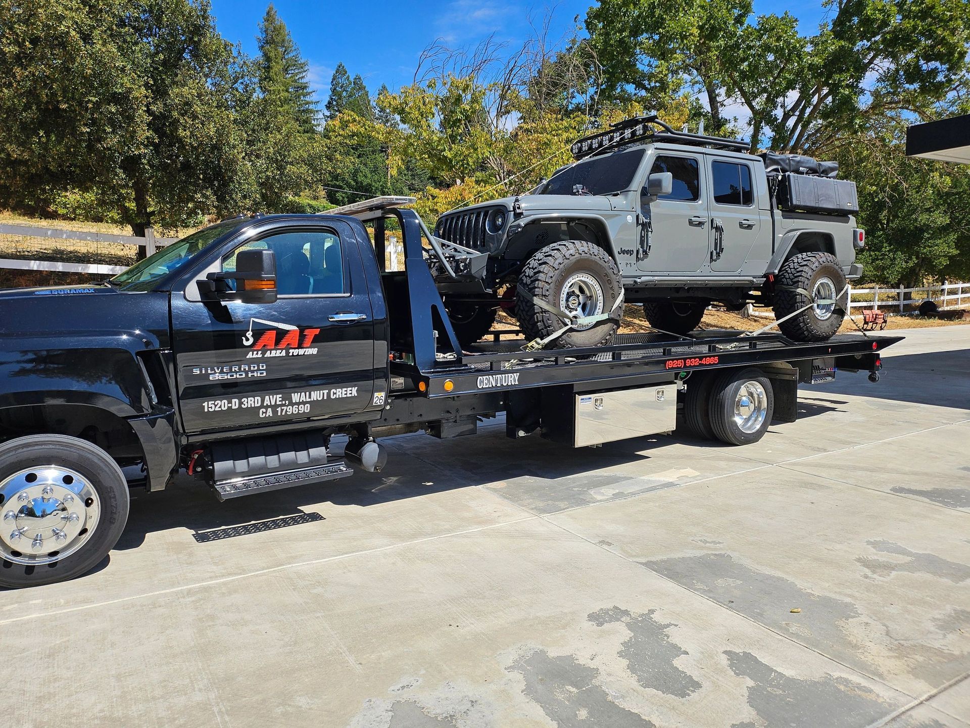 A man is towing a car on a tow truck.