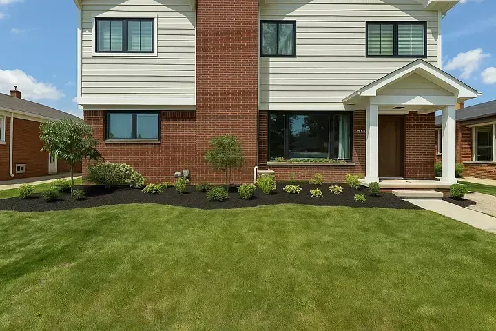 Front view of a two-story house with brick and siding, a lawn, and a front porch