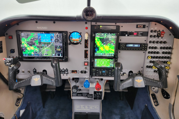 Airplane cockpit with dual flight displays, controls, and instrument panels visible