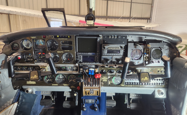 Airplane cockpit instrument panel with gauges, switches, and a central control console
