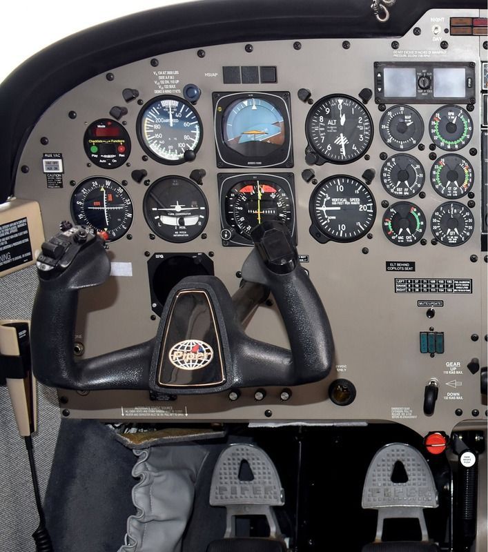 Airplane cockpit instrument panel with dual control yoke and multiple gauges under the windshield