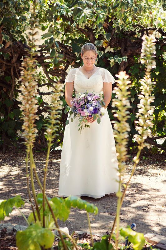 A bride in a white dress is holding a bouquet of flowers.