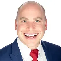 A man in a suit and tie is smiling for the camera.