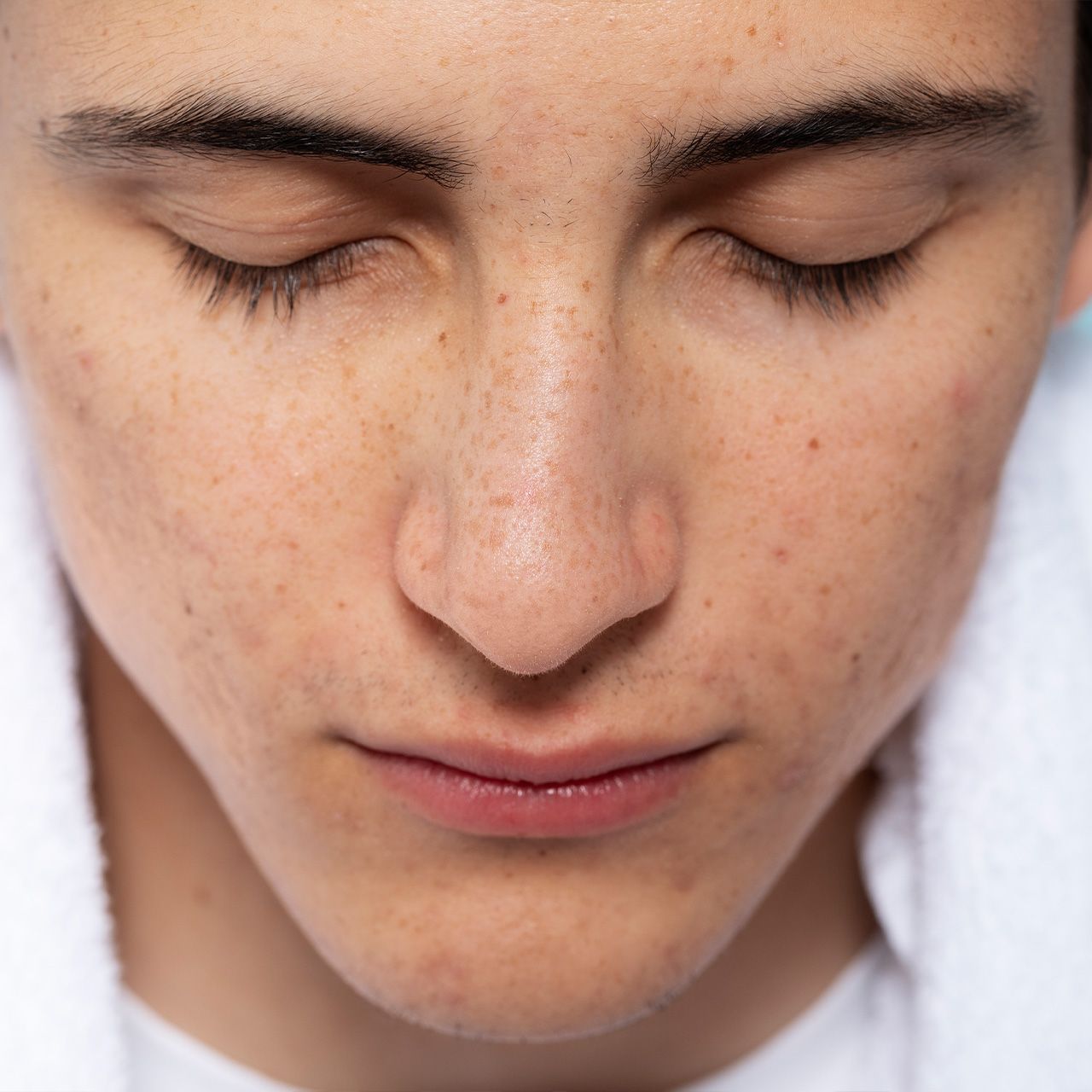 A close up of a man 's face with his eyes closed