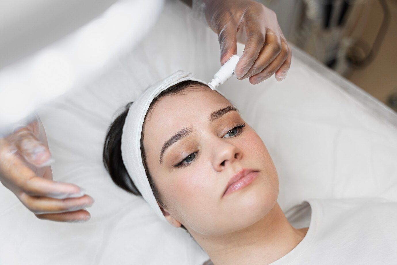A woman is getting a facial treatment at a beauty salon.