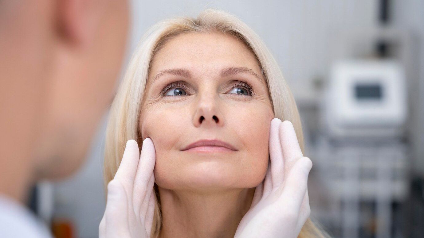 A woman is getting her face examined by a doctor.