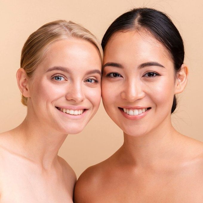Two women are posing for a picture together and smiling for the camera.