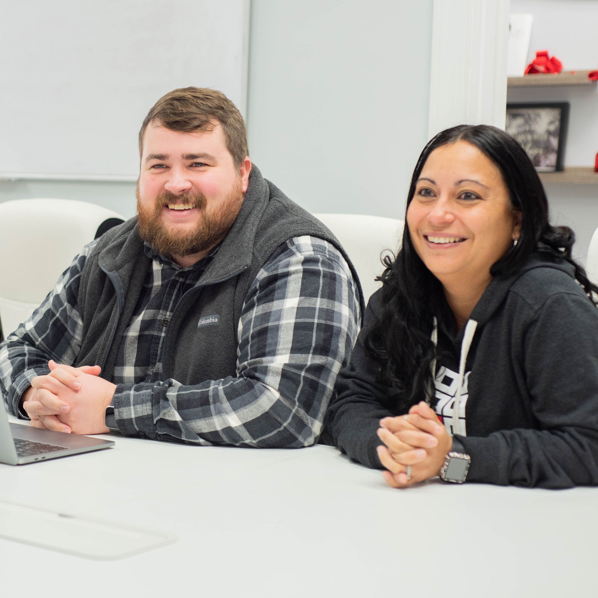 Two Ashley Lay Real Estate team members smiling together at the office