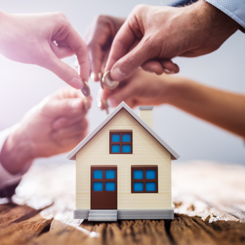 Hands exchanging house keys representing a real estate investment transaction