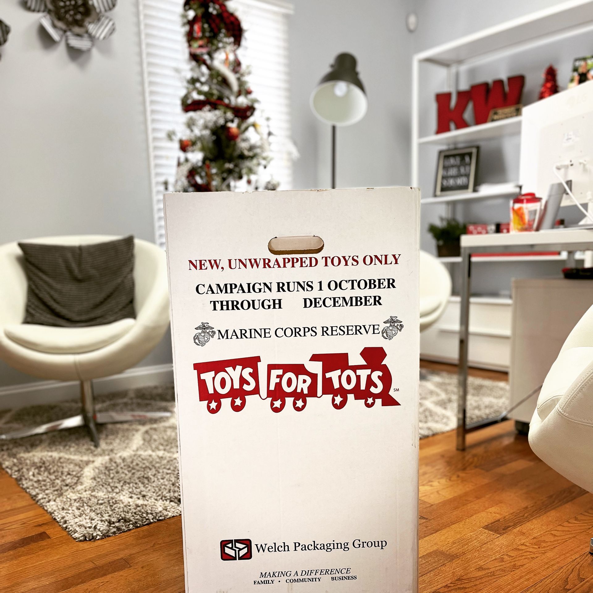 Toys for Tots donation drive sign at the Ashley Lay Real Estate office