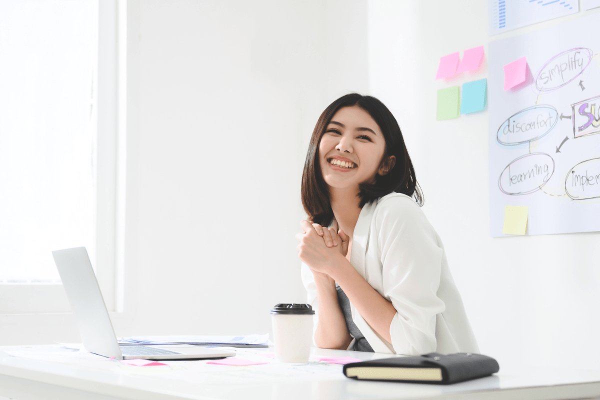 Ashley Lay Real Estate team member smiling at her desk during a brainstorm session
