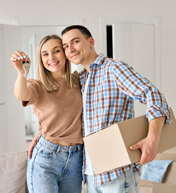 Happy couple holding house keys after purchasing a home with Ashley Lay Real Estate