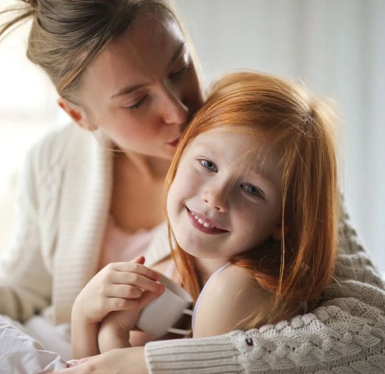 Mother and young daughter smiling together, representing families served by Ashley Lay Real Estate