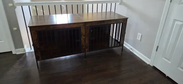 Wooden dog crate or cabinet against a white wall in a room with dark wood floors