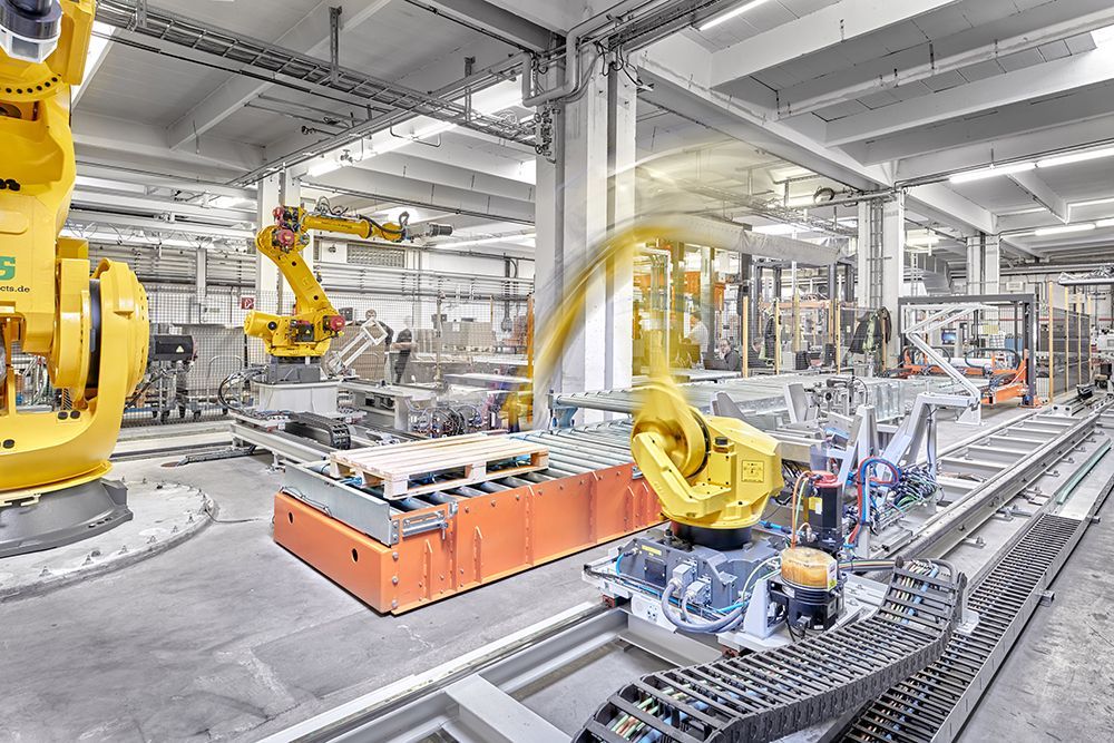 Eine Fabrik mit vielen Robotern, die an einem Förderband arbeiten.