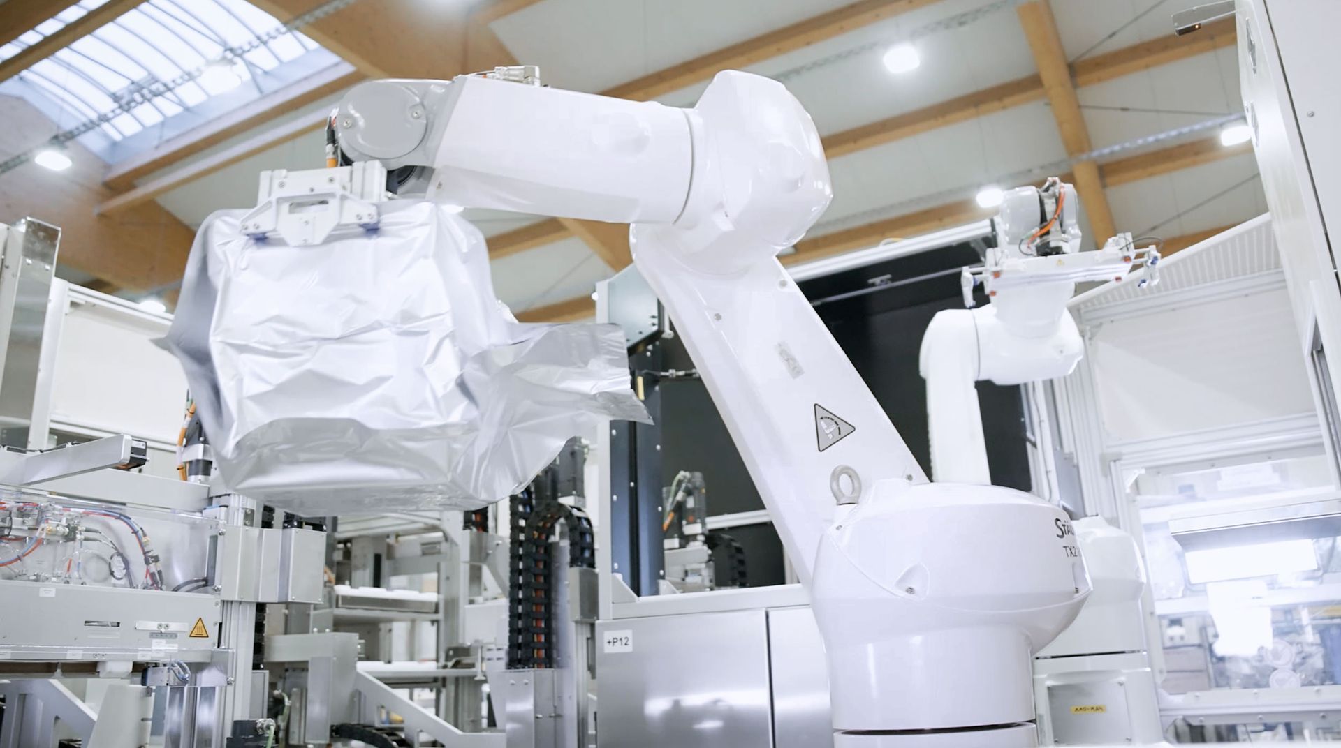 Ein Roboterarm arbeitet in einer Maschine in einer Fabrik.