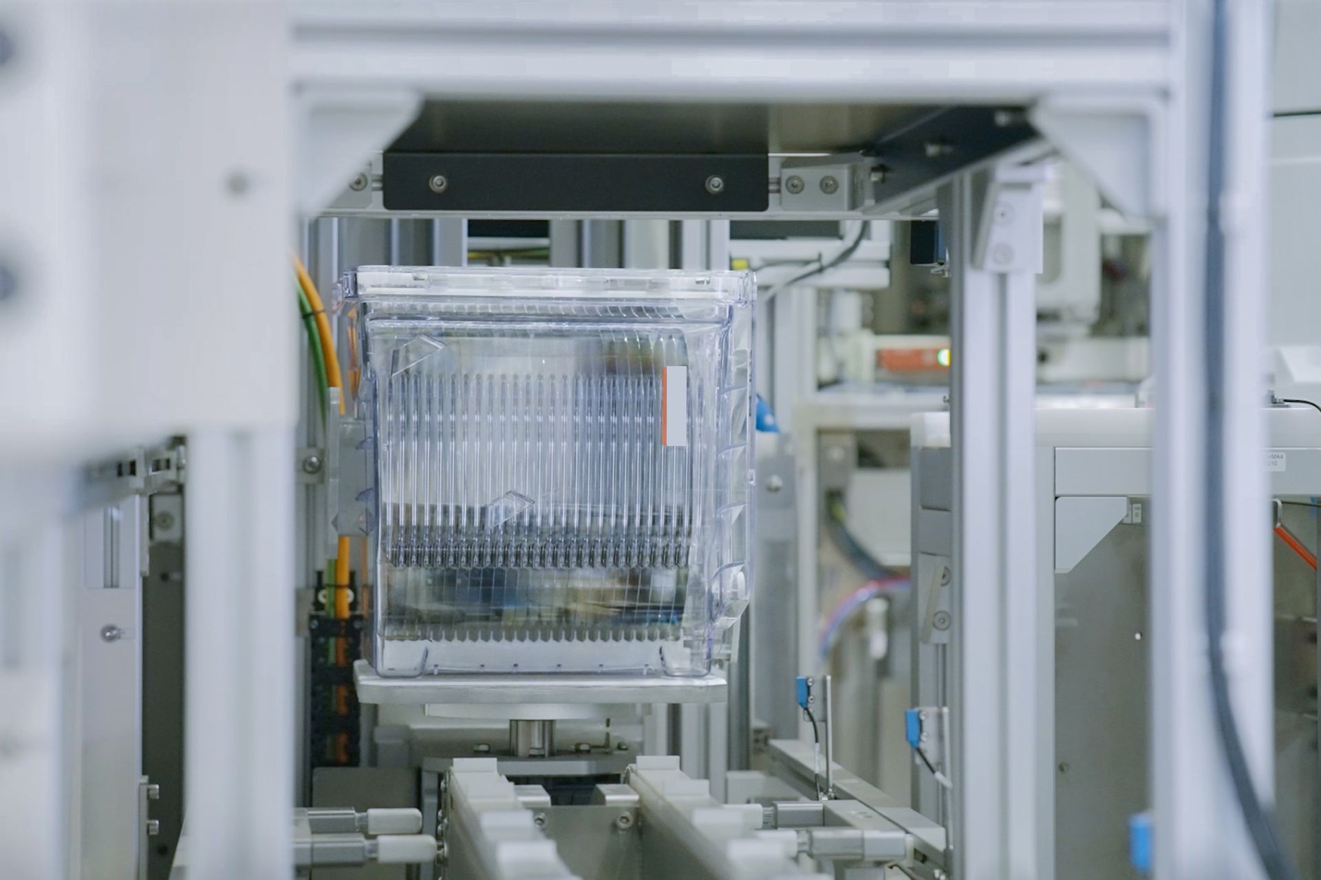 Eine Maschine bewegt einen Plastikbehälter in einer Fabrik.