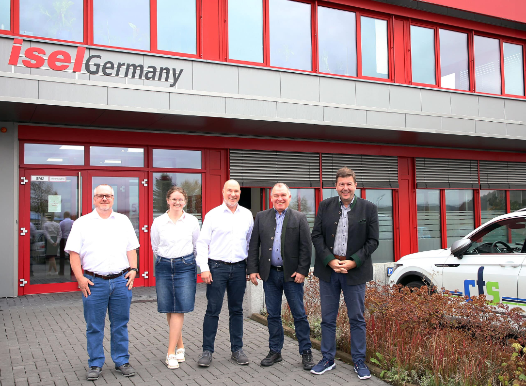 Eine Gruppe von Menschen steht vor einem Gebäude.