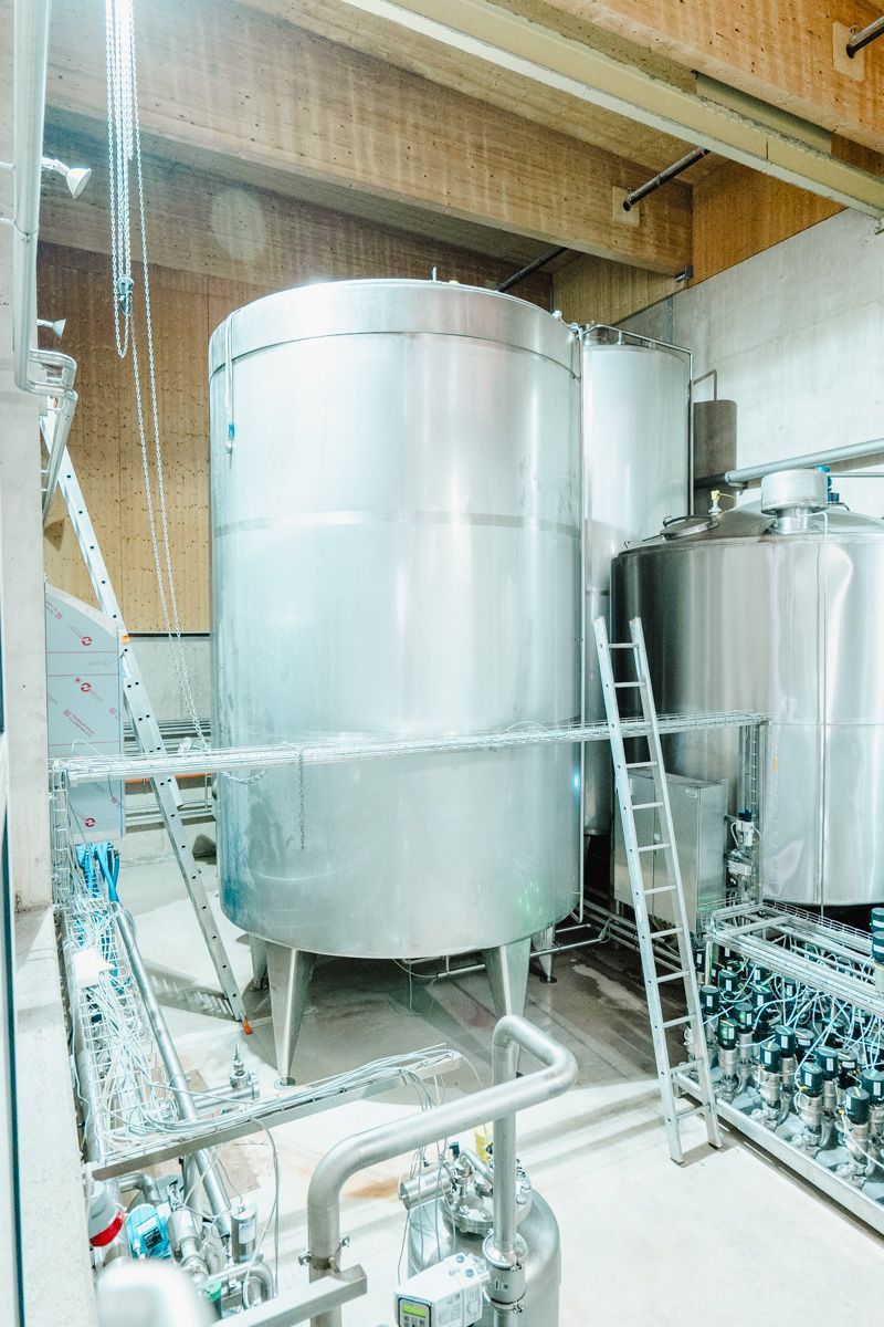 Industrielle Edelstahltanks und Maschinen in einer modernen Fabrikumgebung.