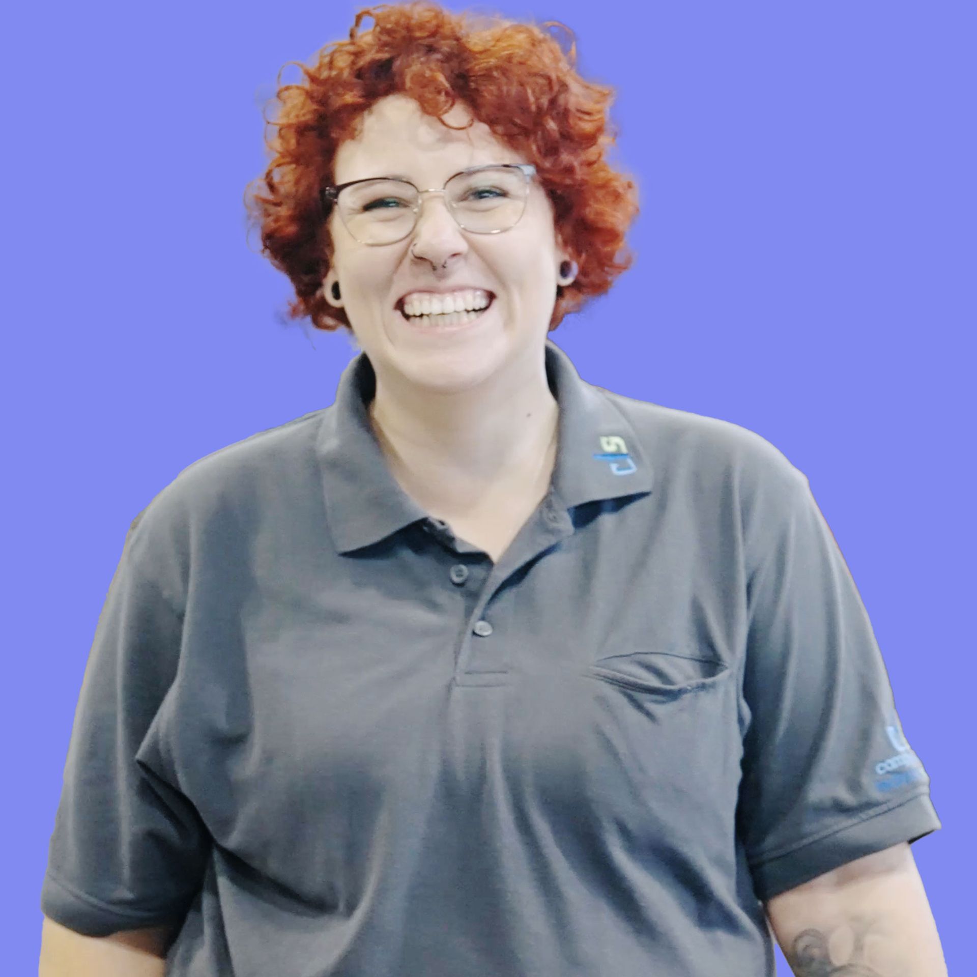 Eine Frau mit Brille und grauem Poloshirt lächelt