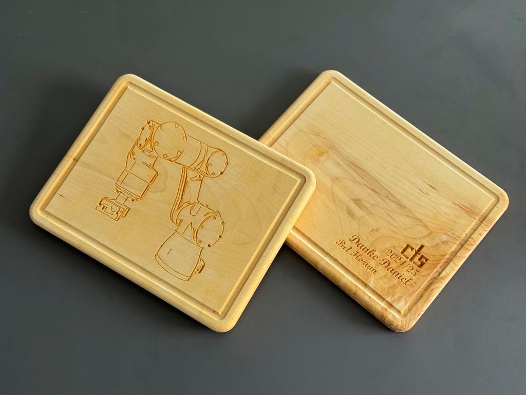 Two wooden cutting boards with a picture of a Robot on them