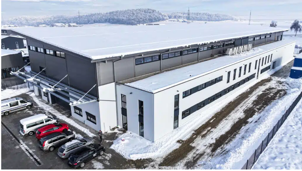 Eine Luftaufnahme einer großen, schneebedeckten Fertigungshalle.