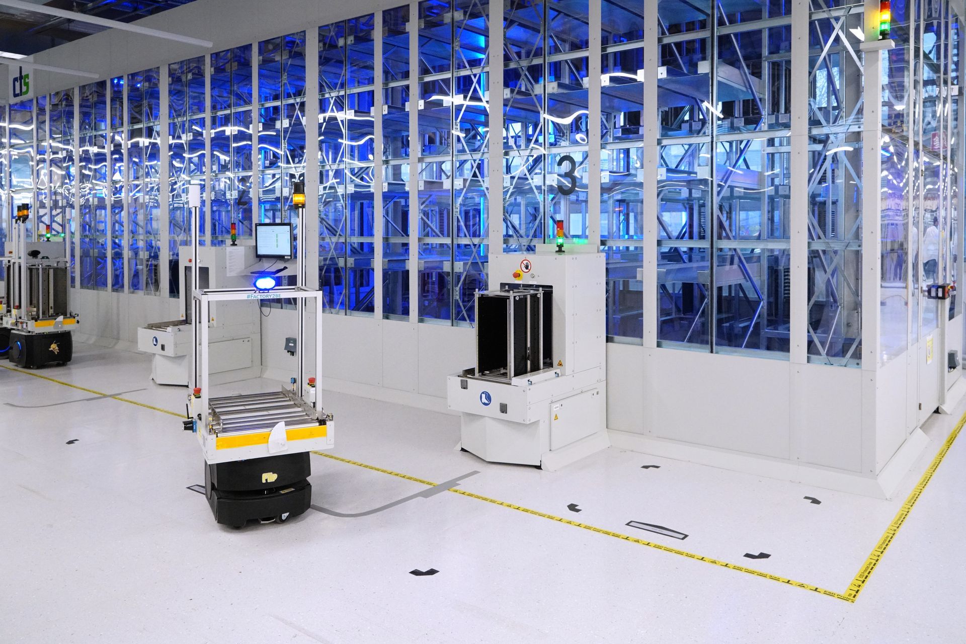 In einer Fabrik steht eine Reihe von Robotern an einem automatisierten Lager.
