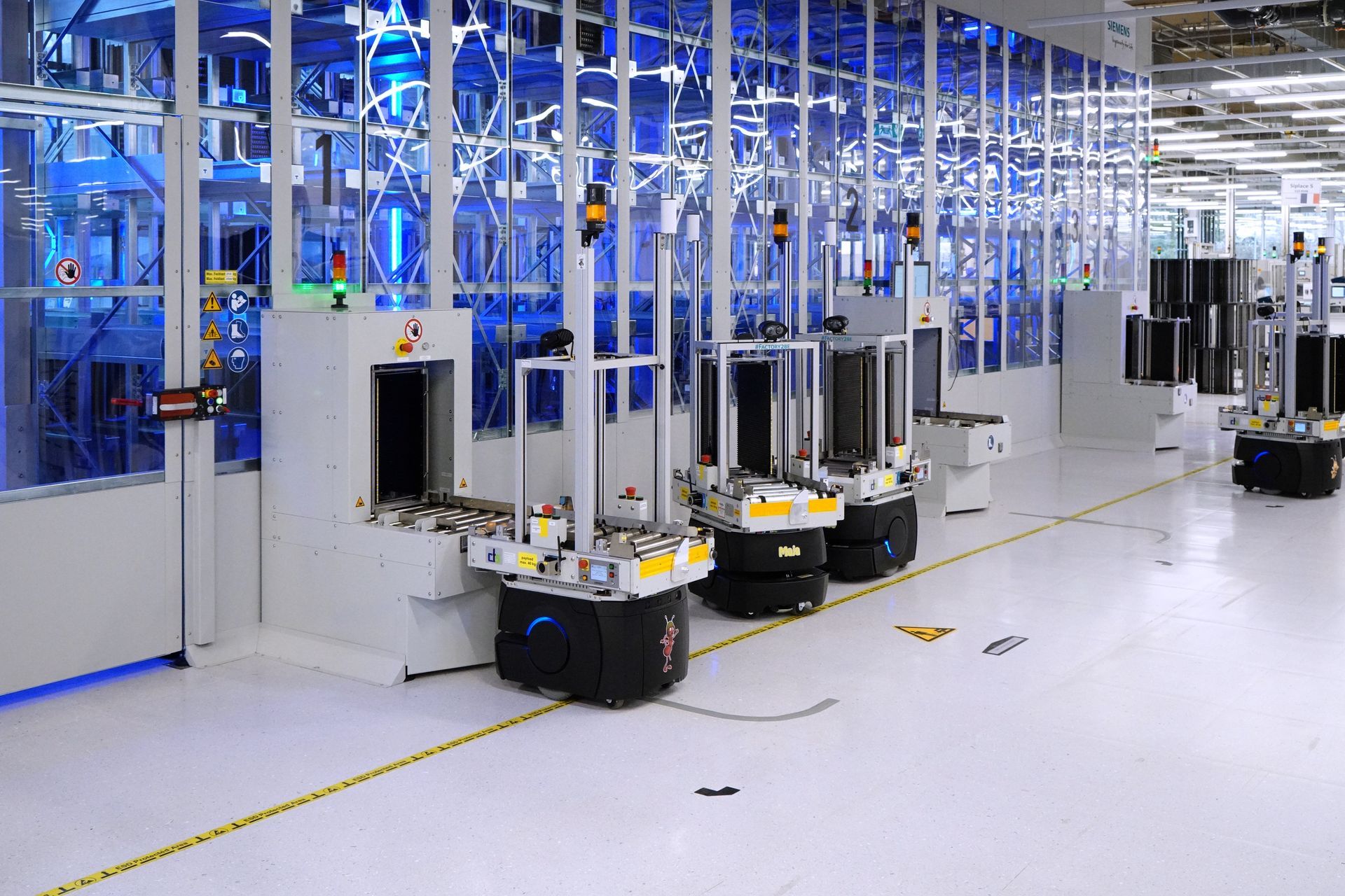 In einer Fabrik steht eine Reihe von Robotern an einem automatisierten Lager.
