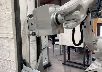 Ein Roboterarm entdrahtet einen Papierstapel.