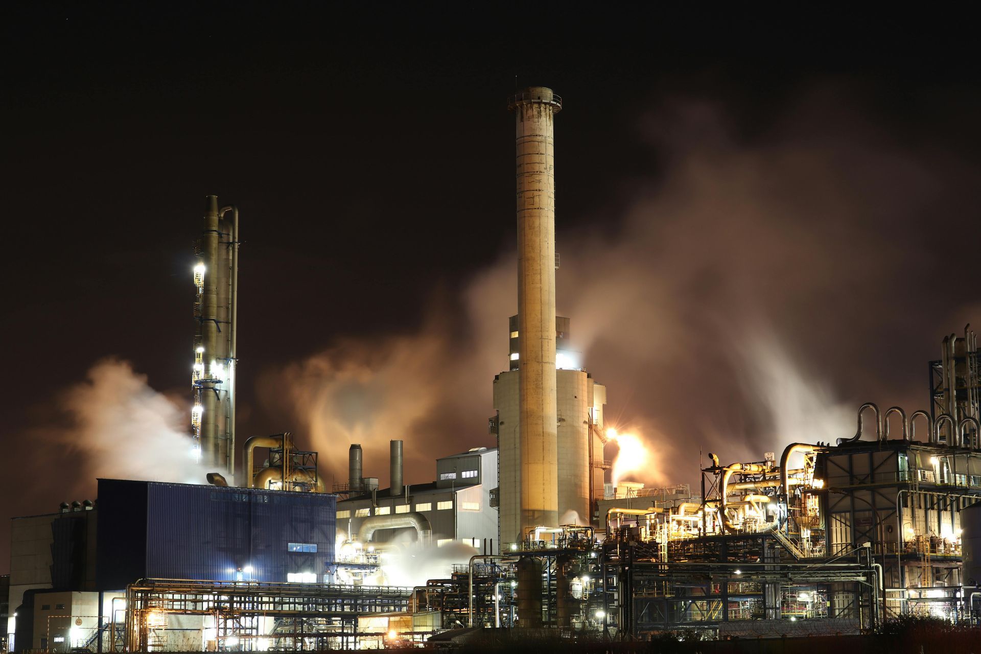 Eine Fabrik bei Nacht mit Rauch aus den Schornsteinen