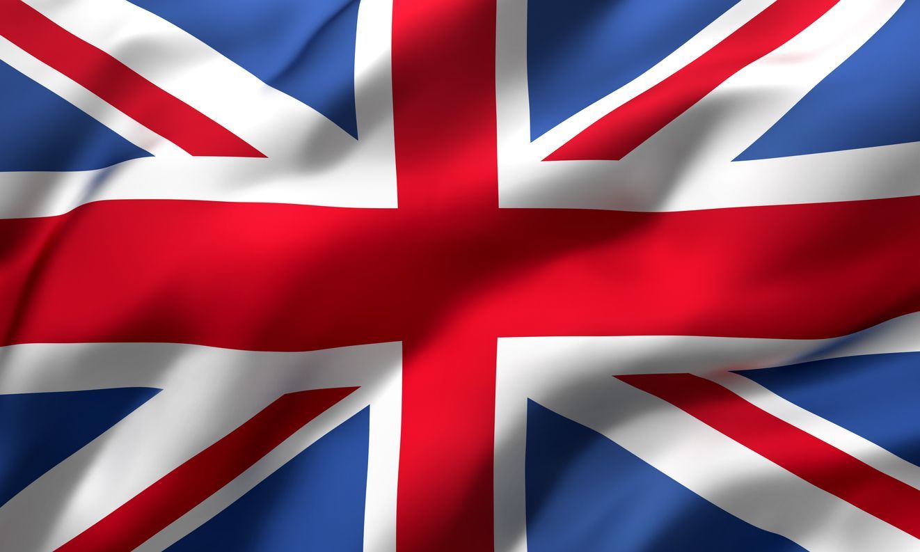 Bandera de Union Jack ondeando con colores rojo, blanco y azul.