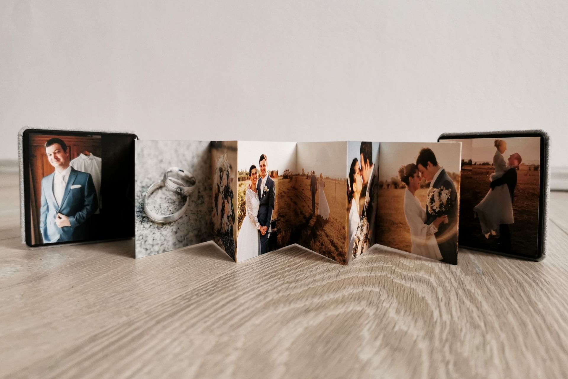 Ein auf einer Holzoberfläche präsentiertes Leporello-Fotoalbum mit Familienfotos