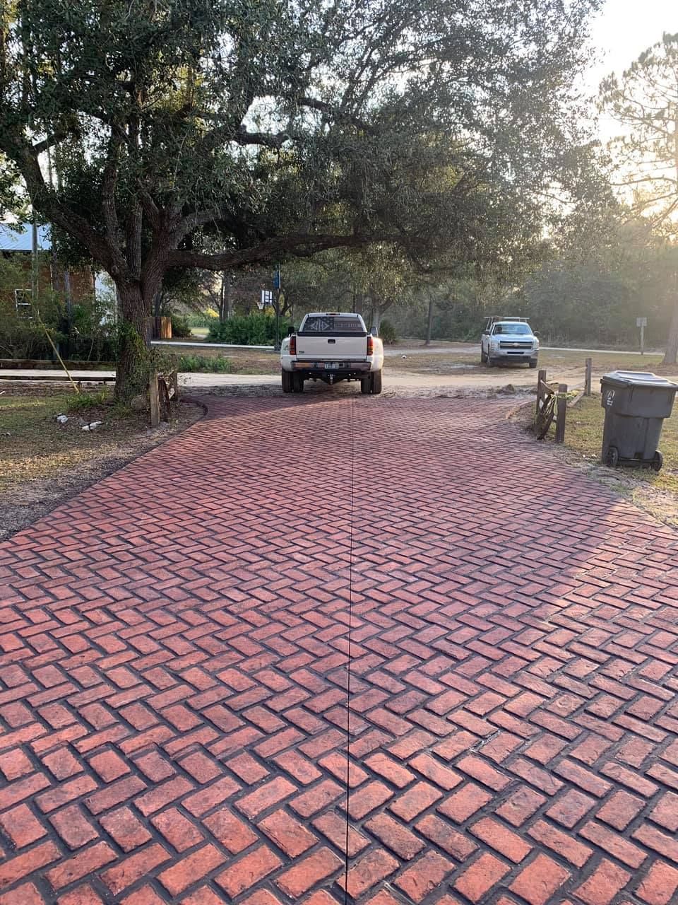 A white truck is parked in a brick driveway.